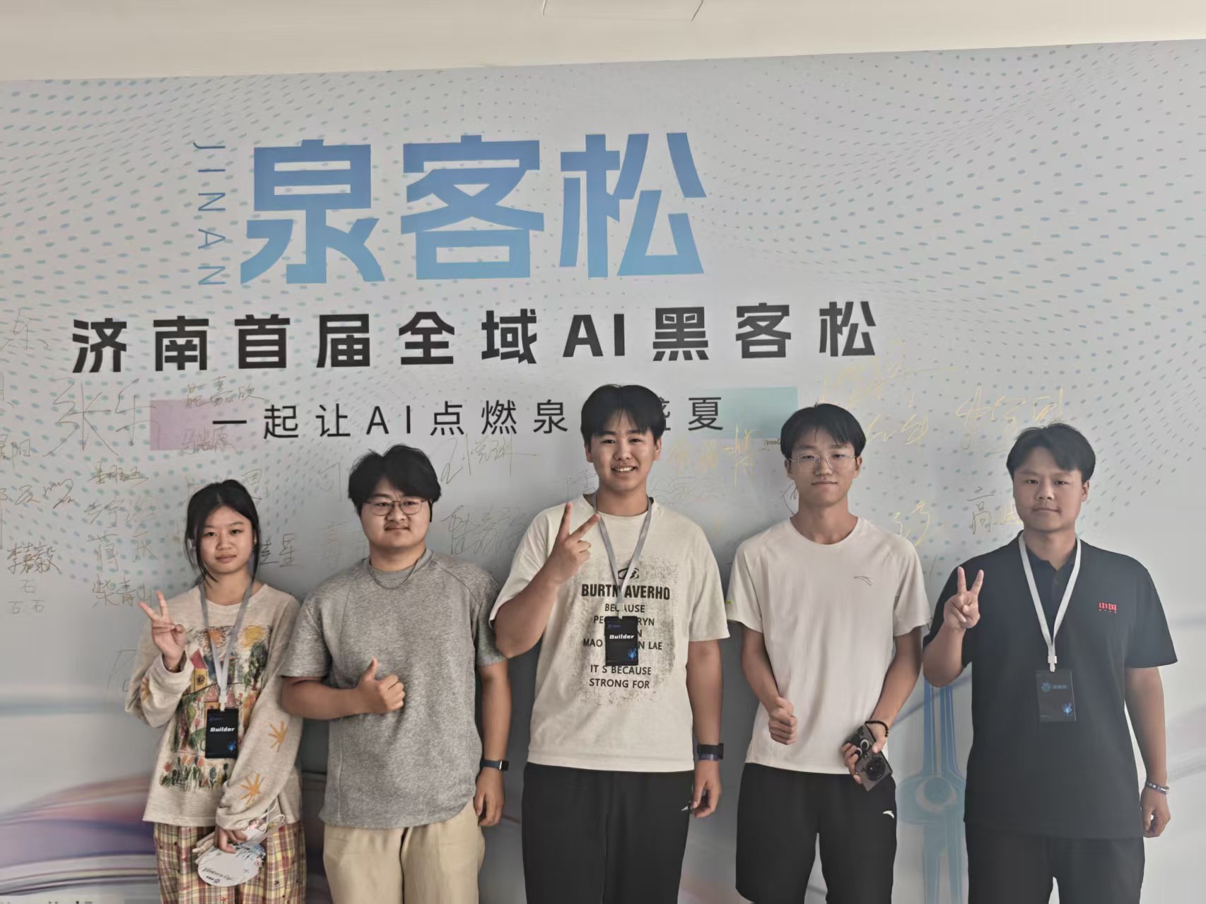 泉客松签到墙前的团队合影